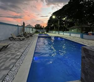 a swimming pool with blue water at dusk at Balbuena Countryside Villa with Private Pool in San Felipe de Puerto Plata