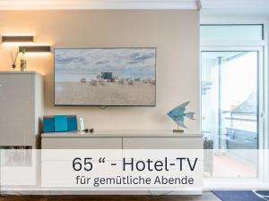 a living room with a hotel tv on the wall at Skriien Mö TOP-Fewo 4 Sterne 5 Min zum Strand Balkon 2 SZ TG Zentrum in Westerland
