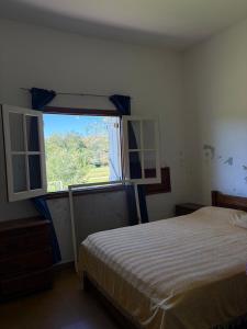 a bedroom with a bed and a large window at Habitación con baño privado con cocina separada in Villa Cura Brochero