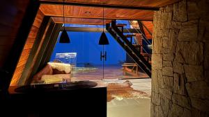 a living room with a large window and a couch at Black Hut in Domingos Martins