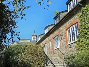 an old stone building with a clock tower in the background at Tuckenhay, Mill Stream - Fme in Ashsprington