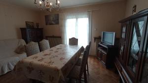 a dining room with a table and a television at Les Collines de Compreignac in Compreignac