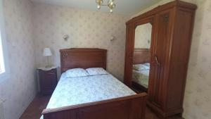 a bedroom with a wooden bed and a cabinet at Les Collines de Compreignac in Compreignac