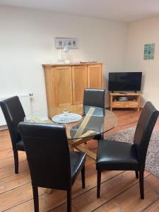 a dining room with a glass table and black chairs at Ferienwohnung Annelie in Zinnowitz