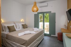 a bedroom with a large bed with towels on it at Le Reve in Aegiali