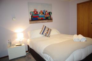 
a bedroom with a bed, a lamp and a painting on the wall at Getawaytoaljon in Mansfield
