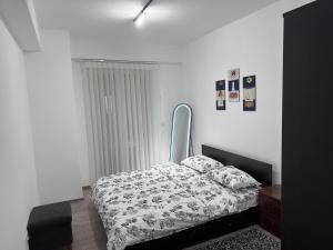 a bedroom with a bed with a black and white comforter at Dialb Apartments in Debar