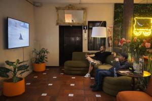 two men sitting on couches in a living room at Viena Internacional B&B - Rooftop in Quito