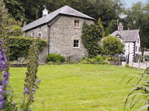 an old stone house in a field of grass at Gamekeepers Cottage - Hw7729 in Llangadog