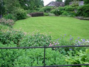 a garden with a field of flowers and a fence at Gamekeepers Cottage - Hw7729 in Llangadog +1 photo