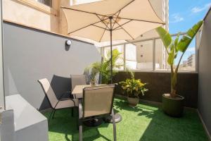 a table with an umbrella in a room with plants at Hotel Britania Miraflores in Lima