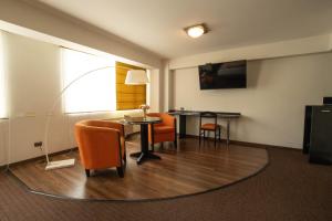 a hotel room with a table and chairs and a desk at Hotel Britania Miraflores in Lima