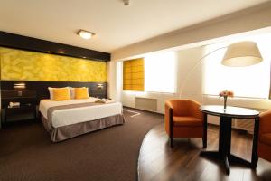 a hotel room with a bed and a table and a chair at Hotel Britania Miraflores in Lima +50 photos