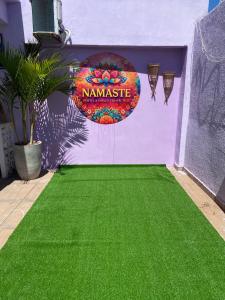 a yard with a green lawn in front of a house at Hostel Namastê in Maceió