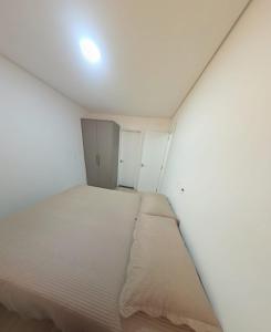 a small bedroom with a bed and a door at Apartamento aconchegante e tranquilo in Foz do Iguaçu +3 photos