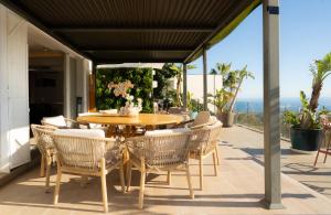 a patio with a wooden table and chairs at Villa Maya Bali Inspired Villa in Mijas