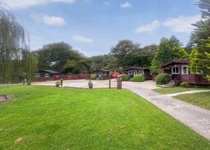 a house with a green yard with houses at Heronstone Lodges in Ystalyfera +59 photos
