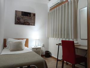 ein Schlafzimmer mit einem Bett, einem Schreibtisch und einem roten Stuhl in der Unterkunft Hotel SQUARE in Sertã + 37 Fotos