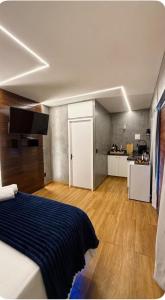 a bedroom with a bed and a kitchen in the background at Canto Flix in Brasília