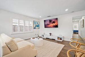 a white living room with a couch and a table at Waterfront Oasis, Heated Pool, MiniGolf, TikiHut in Lake Clarke Shores