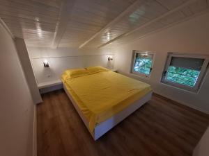 a bedroom with a bed with a yellow bedspread at Villa White Lake - Ohrid Center Lakeside Accommodation in Ohrid