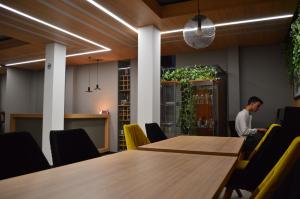 a man standing in an office with a table and chairs at Villa White Lake - Ohrid Center Lakeside Accommodation in Ohrid