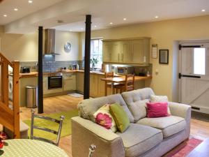 a living room with a couch and a kitchen at Barn End in Pooley Bridge