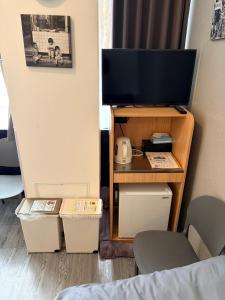 a room with a tv on a stand with a table at Q FOX BLACK DIAMOND HOTEL in Kutchan