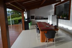 a kitchen with a wooden table and chairs at Pousada Suítes do Lago in Capitólio