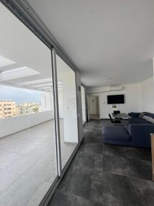 a living room with a blue couch and a tv at Cyprus Apart Hotel in Famagusta