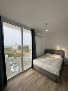 a bedroom with a bed and a large window at Cyprus Apart Hotel in Famagusta