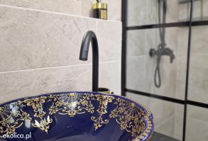 a blue sink with a gold pattern on it in a bathroom at Atlantis villa in Ustka +7 photos