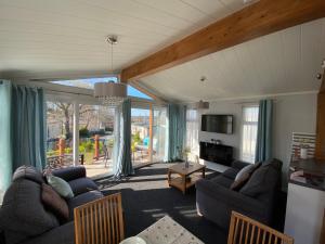 a living room with two couches and a tv at Sunset Lodge in Poole