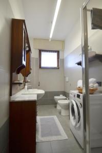 a bathroom with a sink and a washing machine at Gemelli al Lago in Arona