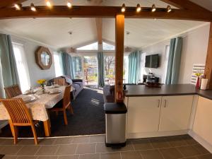 a kitchen and living room with a table and a stove at Sunset Lodge in Poole