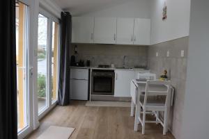 a kitchen with white cabinets and a table and chairs at Estudio Robusto in Monte do Valão