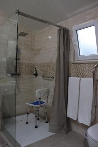 a bathroom with a shower and a chair in it at Estudio Robusto in Monte do Valão