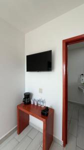 a room with a table with a television on a wall at Hotel Las Arenitas in Mazatlán