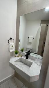 a bathroom with a sink and a mirror at Hotel Las Arenitas in Mazatlán