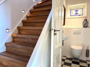 a bathroom with a toilet and a staircase at Villa Verano in Noordwijk aan Zee +14 photos