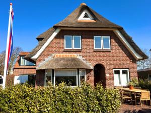 a red brick house with a pitched roof at Villa Verano in Noordwijk aan Zee