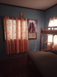 a bedroom with a bed and a window with curtains at Camiguin Island in Mahinog