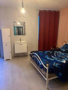 a bedroom with a bed and a red curtain at Rodrigue in Saint-Pierre-le-Moûtier