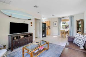 a living room with a tv and a couch at Cottage 3 on Penn - Pool in West Palm Beach