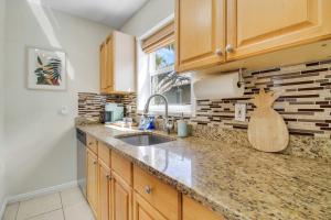 a kitchen with wooden cabinets and a sink at Cottage 3 on Penn - Pool in West Palm Beach