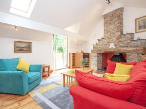 a living room with two couches and a stone fireplace at Mill Bank No 8 - Uk33902 in Ashsprington
