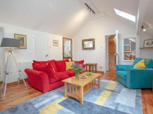 a living room with two red couches and a table at Mill Bank No 8 - Uk33902 in Ashsprington