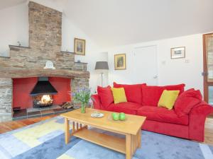 a red couch in a living room with a fireplace at Mill Bank No 8 - Uk33902 in Ashsprington +26 photos