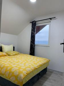 a bedroom with a yellow bed and a window at L&L in Sarajevo