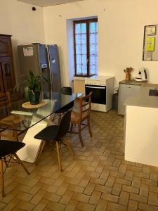 a kitchen with a glass table and chairs in it at Rodrigue in Saint-Pierre-le-Moûtier
